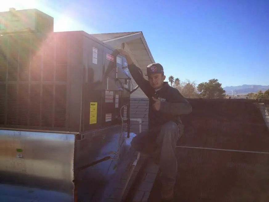 HVAC technician performing AC Tune-Up on a rooftop unit in Lakewood